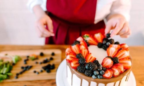 Ένα κομμένο κομμάτι γαμήλιας τούρτας, γαρνιρισμένο με φρούτα, βατόμουρα, φράουλες και βατόμουρα, ποτισμένο με καραμέλα.