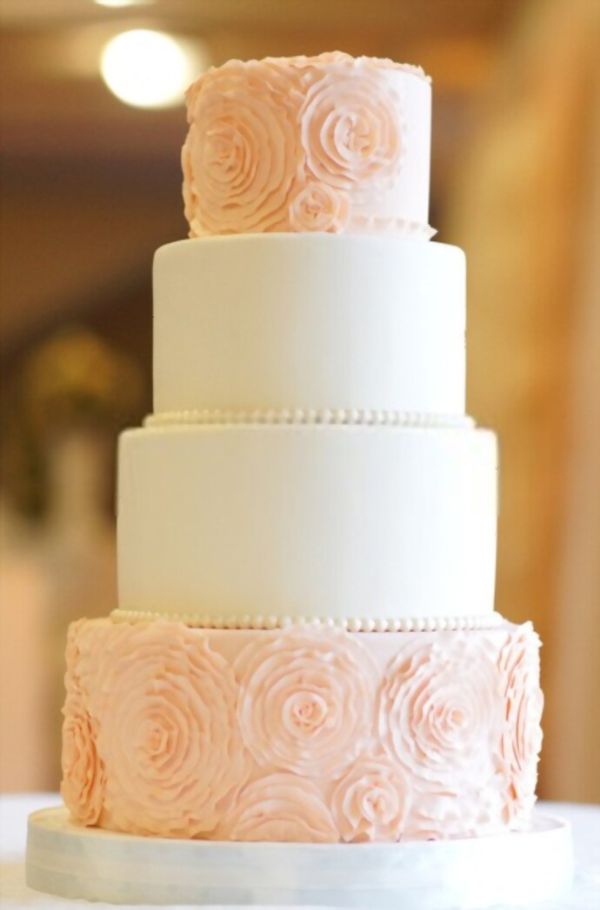 Λευκή floral γαμήλια τούρτα σε εσωτερικό φόντο εστιατορίου