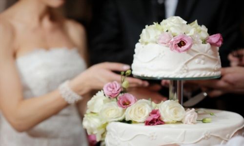 Μια νύφη και ένας γαμπρός κόβουν τη γαμήλια τούρτα τους