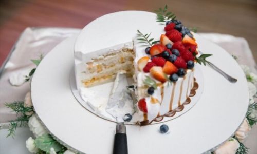 Κομμένη λευκή τούρτα με φράουλες και βατόμουρα