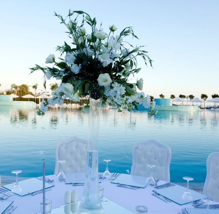 Πισίνα σε κτήμα γάμου με λουλούδια και στολισμένο τραπέζι