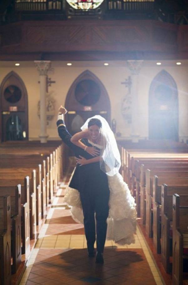 Γαμπρός σηκώνει την νύφη στους ώμους μέσα σε εκκλησία
