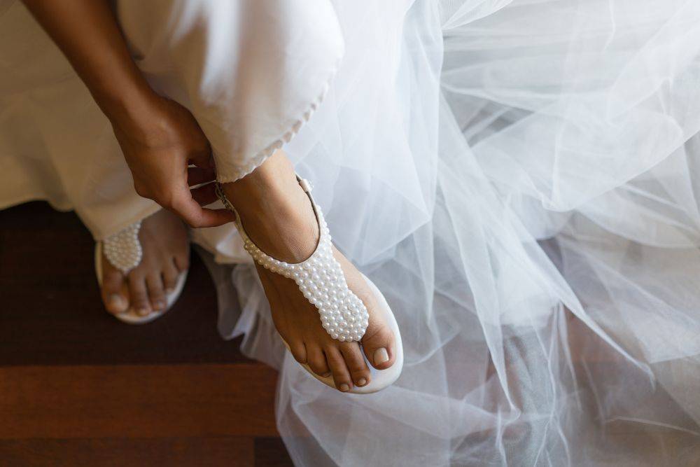 Σανδάλια νύφης με εντυπωσιακό νυφικό. Παπούτσια για γάμο σε νησί 