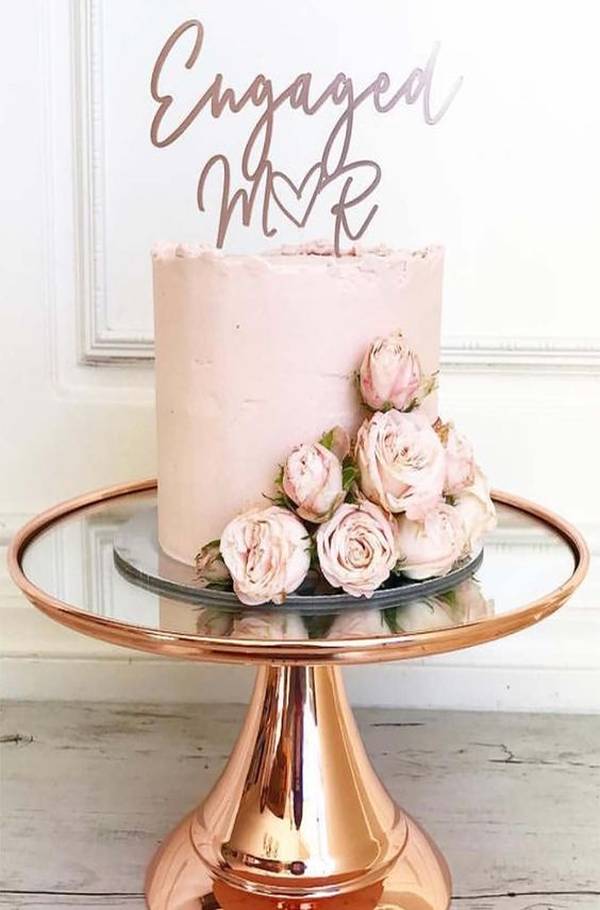 Εντυπωσιακή τούρτα αρραβώνα με λουλούδια πάνω σε γυάλινο τραπέζι