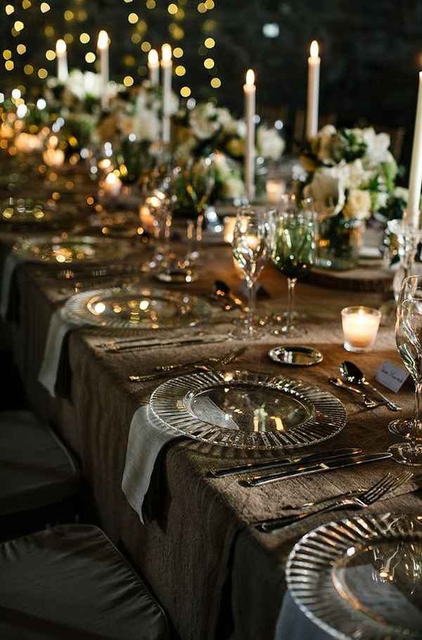 Πανέμορφα διακοσμημένα πιάτα, ποτήρια και κεριά σε χριστπυγεννιάτικο γάμο