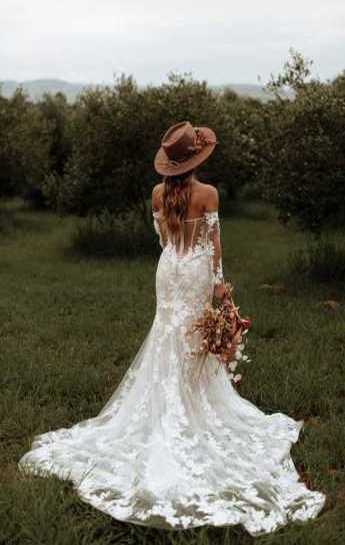 Boho νύφη με καπέλο φωτογραφίζεται στην φύση