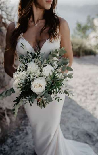 Νύφη κρατά ανθοδέσμη με λευκά λουλούδια