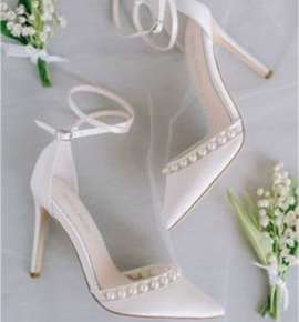 Λευκά νυφικά παπούτσια σε γκρί φόντο με λουλούδια