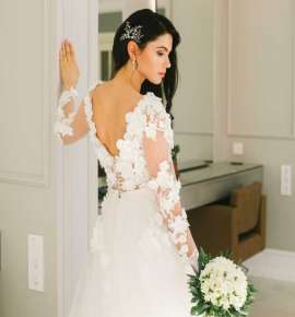 Όμορφή νύφη φοράει νυφικό φόρεμα και κρατάει ανθοδέσμη