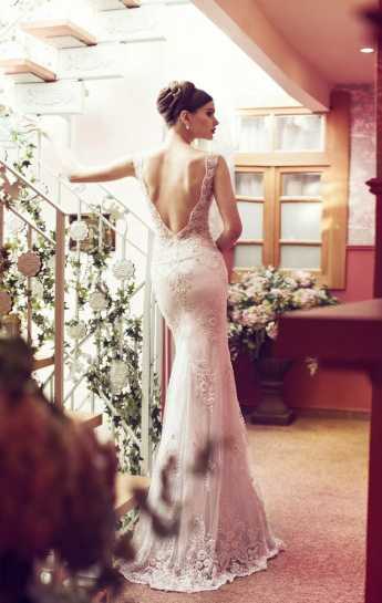 Elegant νύφη φοράει νυφικό φόρεμα με ανοιχτή πλάτη