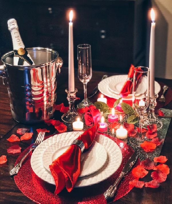 Ρομαντικό δείπνο με κεριά, σαμπάνια και κόκκινα ροδοπέταλα