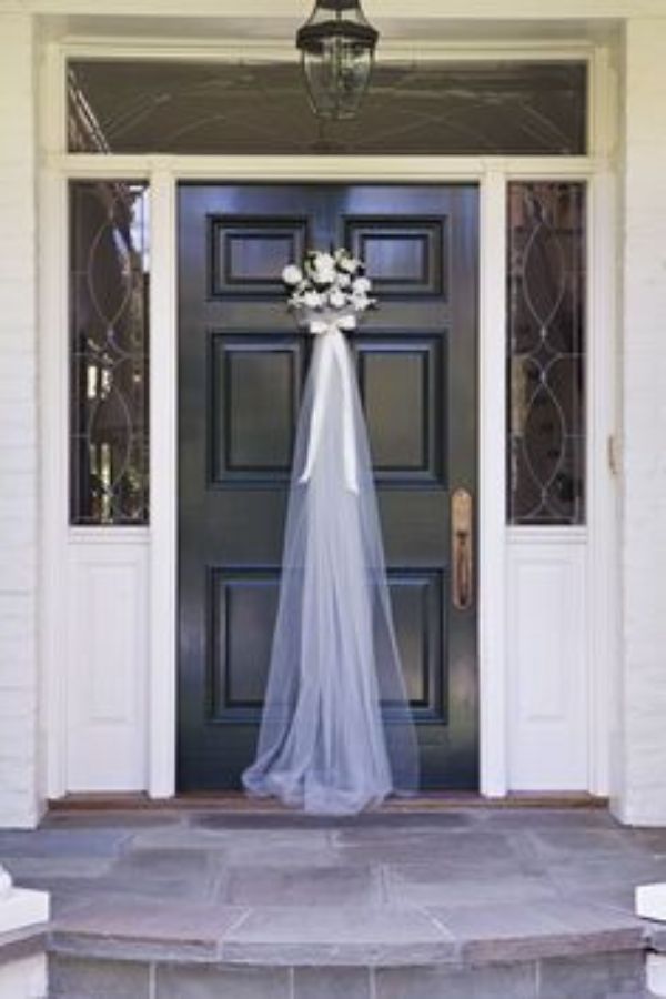 Στολισμός εξωτερικής πόρτας σπιτιού για γάμο με τούλι και λουλούδια