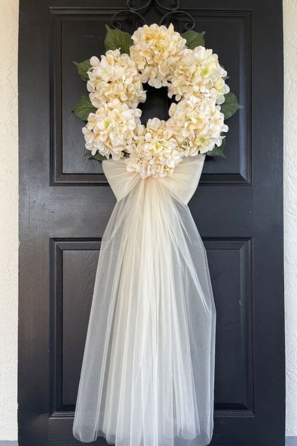 Στολισμός πόρτας για γάμο με τούλινο φιόγκο και λουλούδια